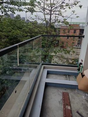 Buitendeck raamloze glazen leuning met handgreep op het glazen dak